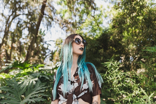 Stylish young woman standing in front of plants