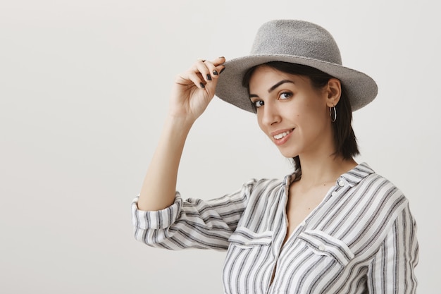 Foto gratuita elegante giovane donna che indossa cappello e sorridente