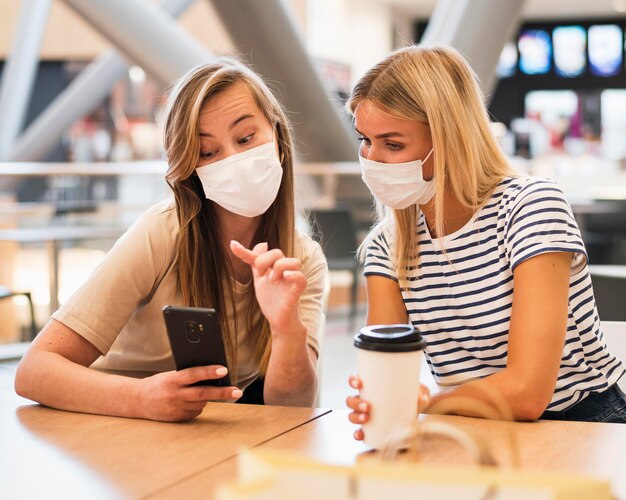 Stylish young women checking mobile phone