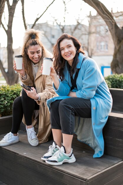 Stylish young women enjoying coffee together