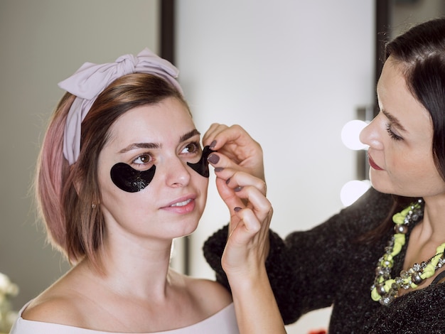 Stylist applying mask on client