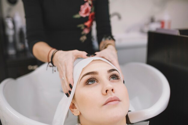 Stylist drying hair of customer with sheet