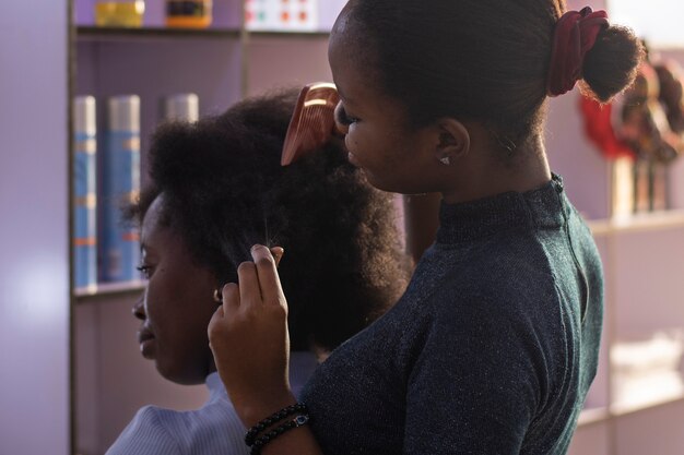 Stylist woman taking care of her client afro hair