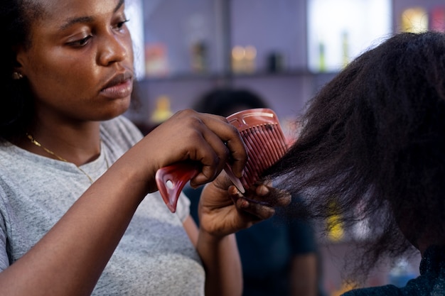 Stylist woman taking care of her client afro hair