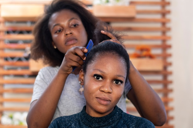 Foto gratuita stilista donna che si prende cura dei suoi capelli afro cliente