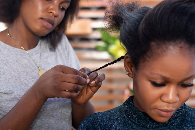 クライアントのアフロヘアーの世話をしているスタイリストの女性