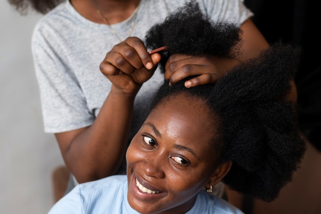 Free photo stylist woman taking care of her client afro hair