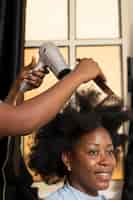 Free photo stylist woman taking care of her client afro hair