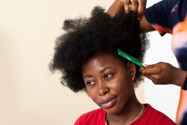 Stylist woman taking care of her client afro hair