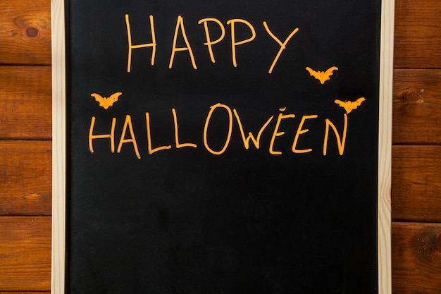 Free photo stylized happy halloween writing on blackboard