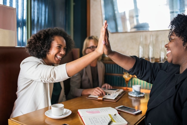 Free photo succesful businesswomen giving a high five