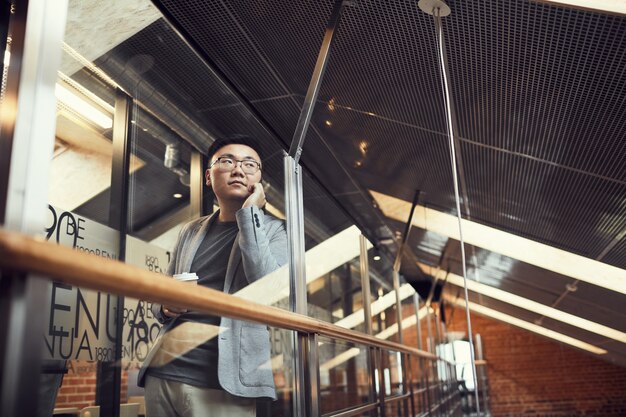 Successful asian businessman speaking by smartphone in office