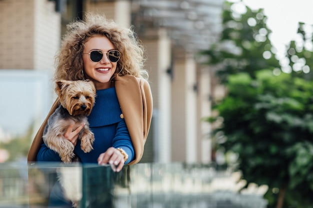 Successful attractive woman holding Yorkshire terrier.