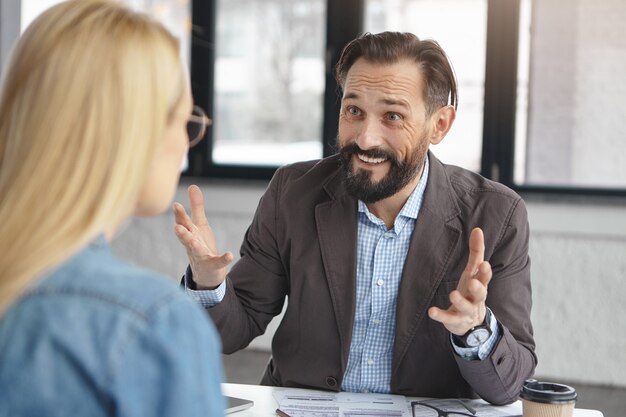 Successful bearded man employer interviews woman for job