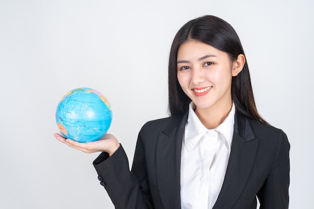 Successful beautiful Asian business young woman holding vintage map of the globe world map in hand 