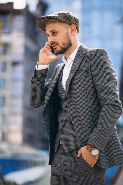 Successful business man by the skyscraper talking on the phone