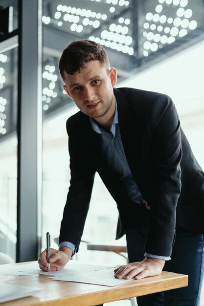 Successful business man signing documents in a modern office