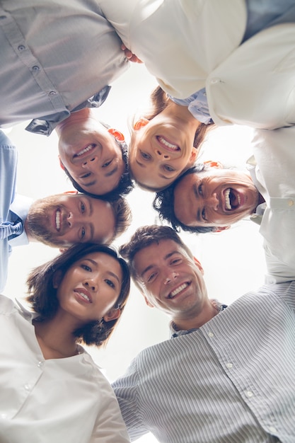 Free photo successful business team embracing and smiling