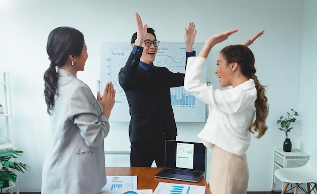 성공적인 비즈니스 팀이 회의 중 아시아 기업인 축하 행사에서 손뼉을 치고 있습니다.