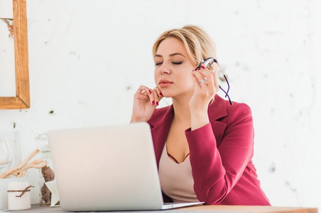 Successful business woman enjoying her work in home office. closeup photo of elegant charming lady smiling making up plan for weekend, dreaming after work day. favorite job, relax, free time concept.
