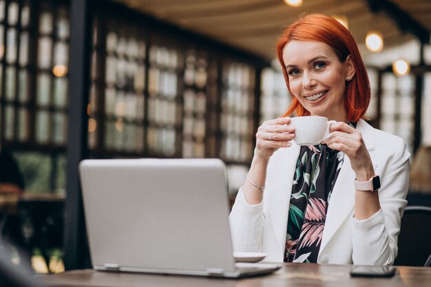 Successful business woman working on laptop in a cafe