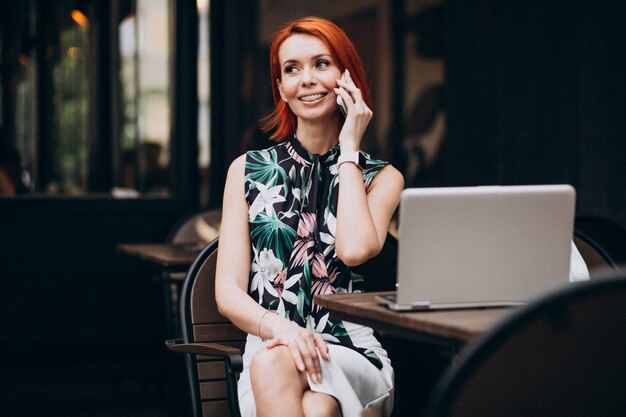 Successful business woman working on laptop in a cafe