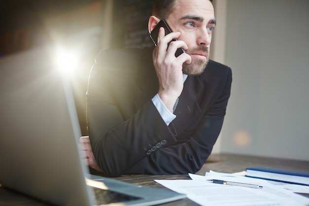 Free photo successful businessman calling by phone while working