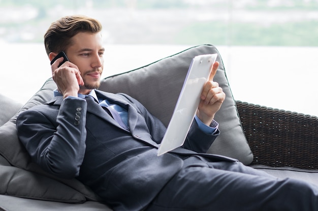 Successful Businessman Discussing Document on Phone