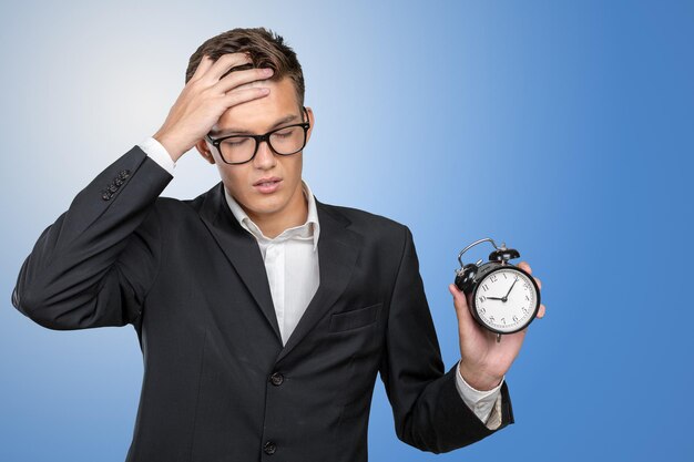 Successful businessman in formal wear pointing at clock