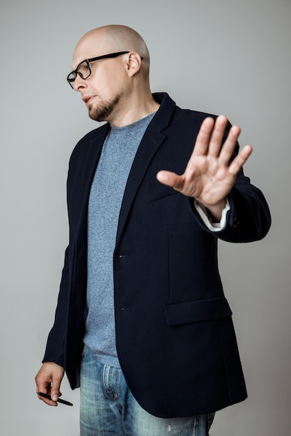 Successful businessman in glasses showing stop over beige background