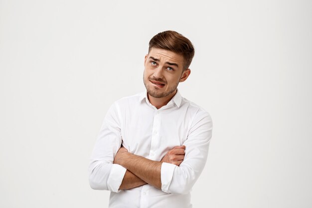 Successful businessman thinking, posing with crossed arms.