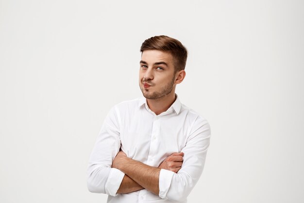 Successful businessman thinking, posing with crossed arms.