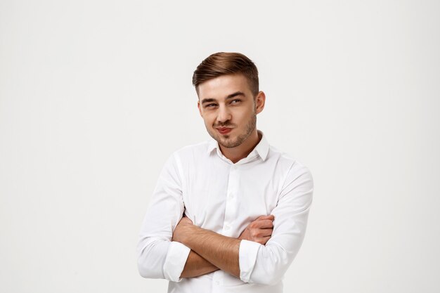 Successful businessman thinking, posing with crossed arms.