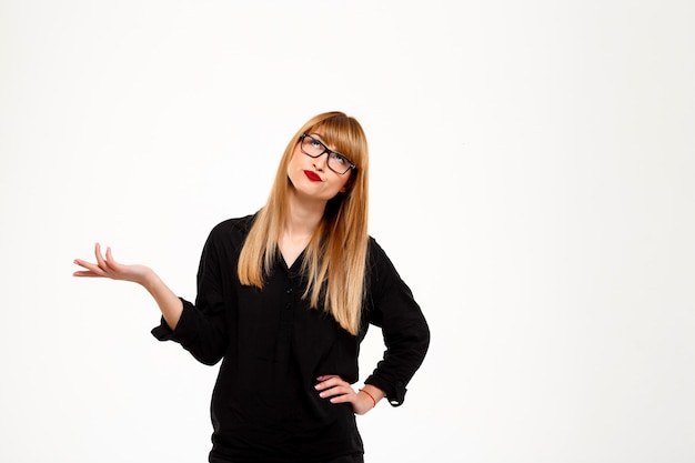 Successful businesswoman gesturing or thinking over white wall Copy space