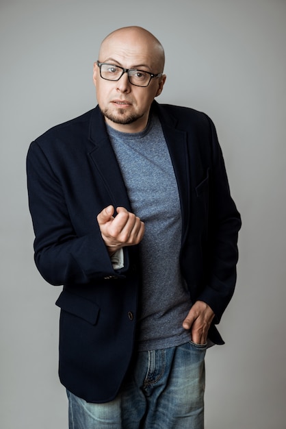 Successful confident businessman in glasses speaking over beige wall.