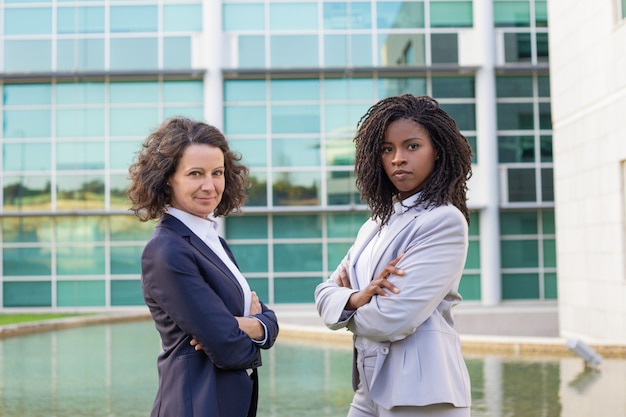 Free photo successful female mix raced business partners posing outside