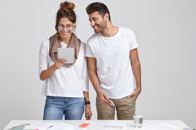 Successful glad female speaker holds modern touch pad