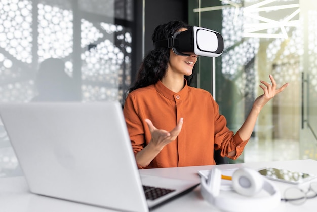 Free photo successful latin american woman in office using vr glasses for video call and chatting online in