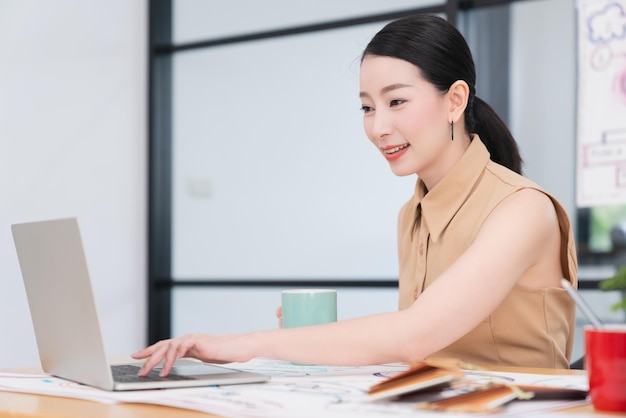 Successful leadership smart attractive asian female working with laptop confident and cheerful smile office background