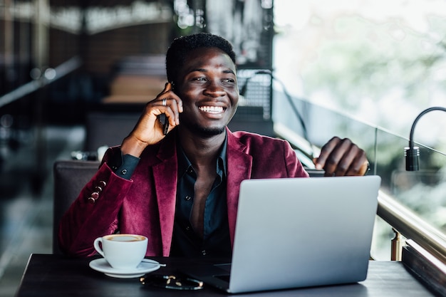 Successful male freelancer connecting to wireless via laptop, thoughtful businessman work on net-book while sitting at table in modern coffee shop interior.