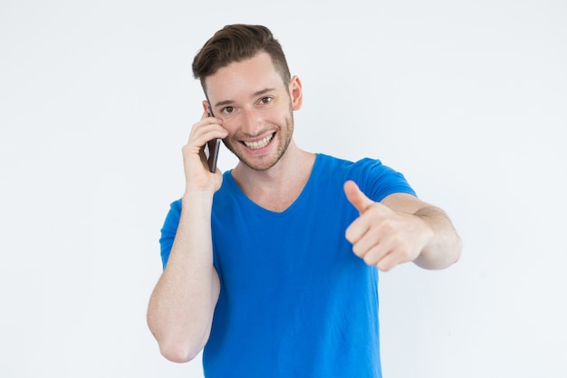 Successful man using phone and showing thumb-up
