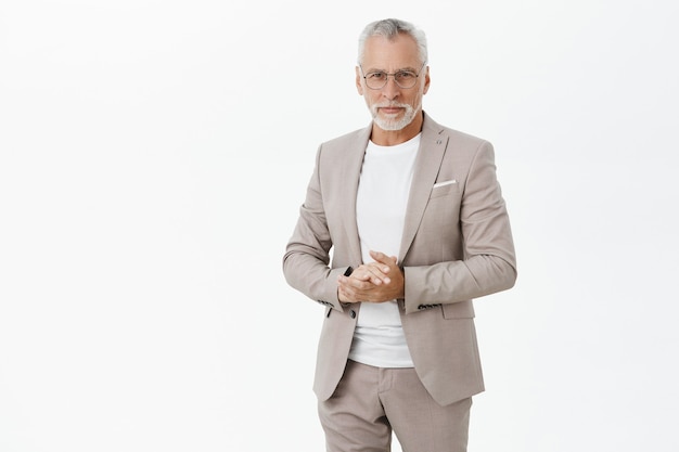successful old businessman in suit and glasses looking confident
