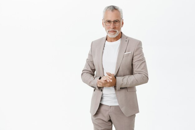 successful old businessman in suit and glasses looking confident
