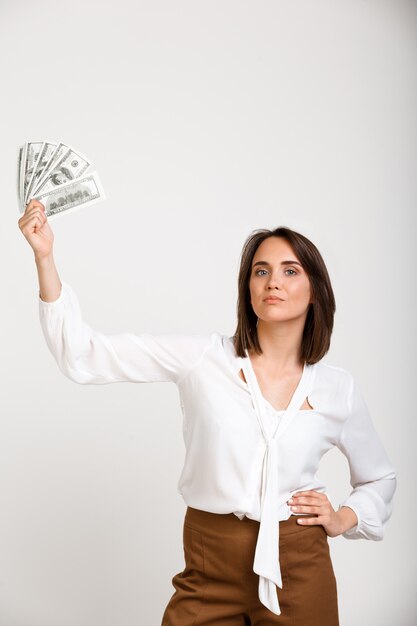Successful rich fashion woman showing money
