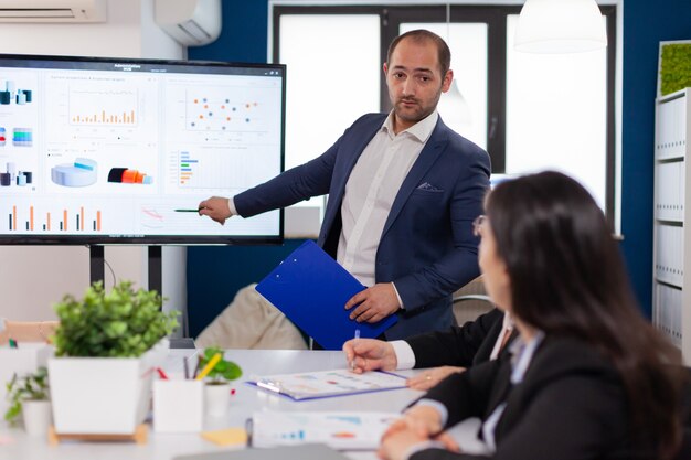 Successful team leader briefing pointing explaining project in conference room brainstorming