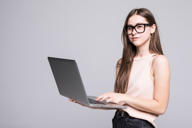 Successful woman is standing on isolated on white wall