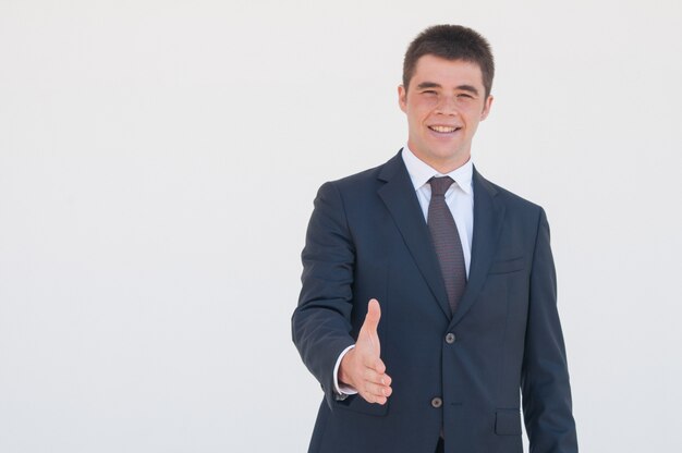 Successful young business leader offering hand for handshake