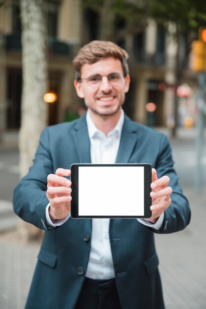 흰색 화면 디스플레이와 디지털 태블릿을 보여주는 성공적인 젊은 사업가