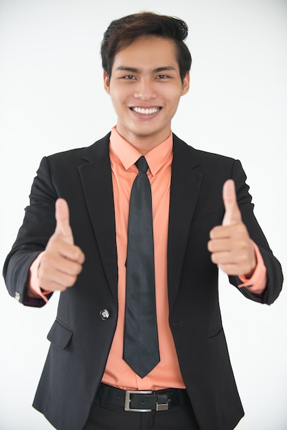 Successful young businessman showing thumbs up