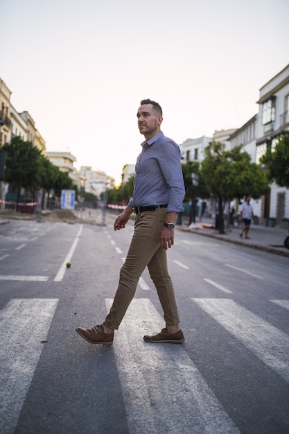 Successful young businessman walking in the street during daytime